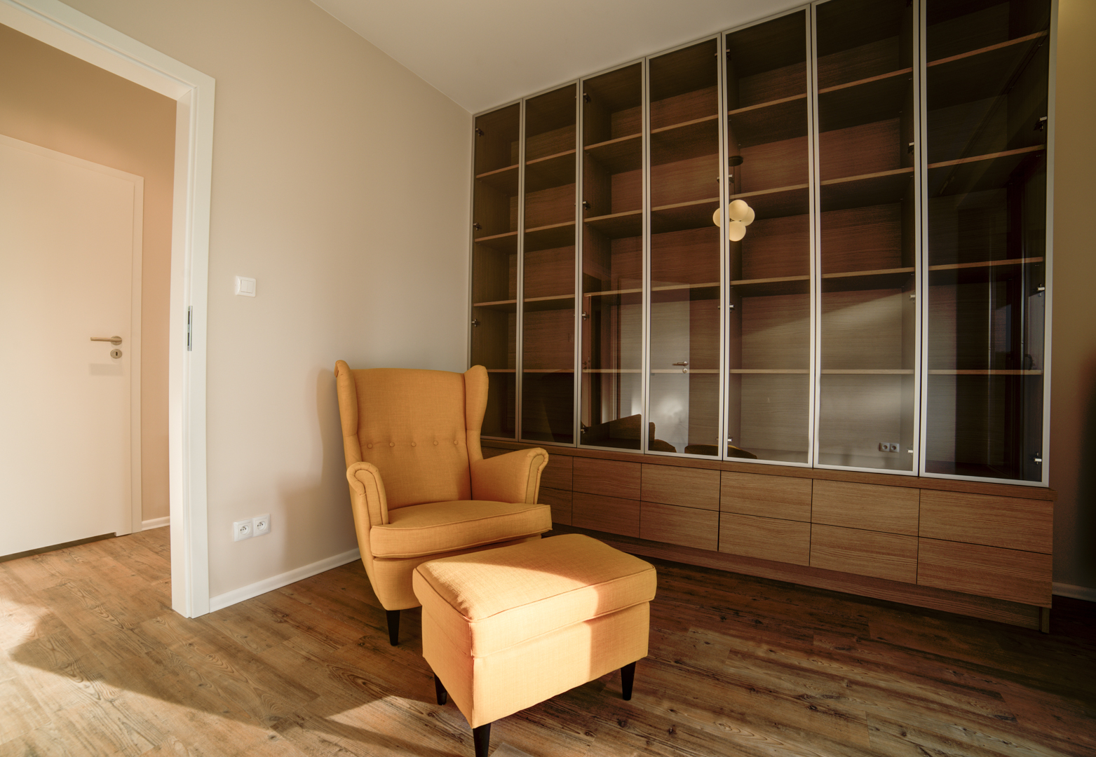perfectspace-wnetrze-urzadzone-w-stylu-retro-przeszklona-witryna-i-stylowy-fotel-z-podnozkiem